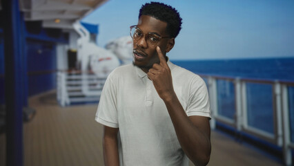 Fototapeta premium Man wearing white polo shirt and glasses standing on boat deck with arms at sides; quiet reflection.