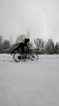 Static vertical Riga shot of cyclist stopping in snow showing basic human needs
