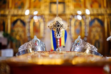 Orthodox wedding crowns and cross on the altar inside a church in Romania
