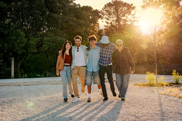 Group of multi-ethnic friends walking together toward a successful future. Happy young people...