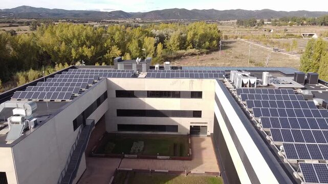 Aerial shot of a modern office building or research center with the roof covered with photovoltaic solar panels.