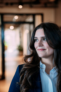 Confident businesswoman in office looking away with a slight smile