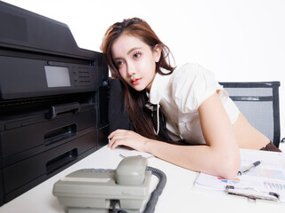 Asian pretty confident young woman in modern office attire smile sitting pose at desk beside printer laptop telephone plant, Professional business portrait in white studio fashion  style background.