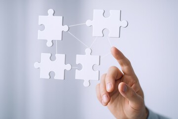 Connecting Ideas: Hand Connecting Jigsaw Pieces Illustrating Teamwork, Solutions, and Strategy in Business on White Background