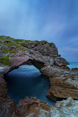 Rock arch formation along the rugged rocky coastline at Arniston, Overberg, Western Cape, South Africa. Dramatic natural arch, ocean waves, and coastal landscape perfect for travel and nature 