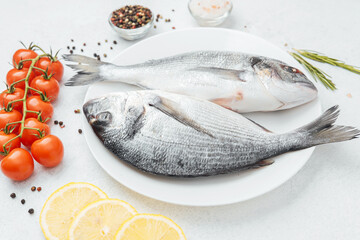 Raw dorado fish with tomatoes lemon and spices on white background