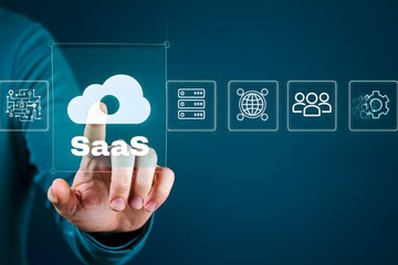 Hand touching a cloud icon with saas text and various technology icons on a blue background display