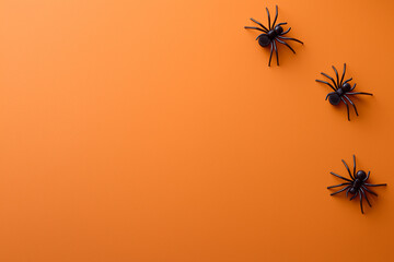 Orange background with spiders in Halloween style. 