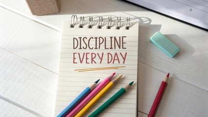 Motivational Note on Notepad Surrounded by Colorful Pencils and Stationery Items on a Bright Wooden Desk