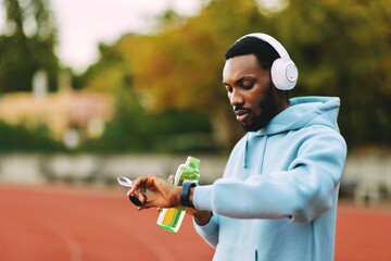 Athlete checking workout progress on smartwatch and hydrating