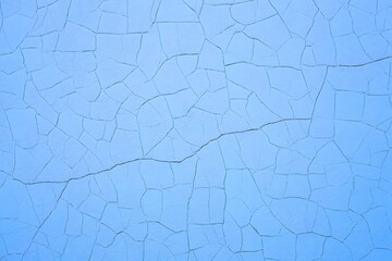 A close up of a light blue painted surface with a network of cracks running across the entire surface