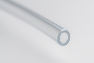 A macro shot of a transparent plastic or glass tube with a hollow center, showcasing its clarity, smoothness, and cylindrical precision.