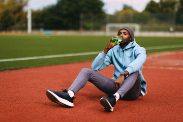 Athlete hydrating on running track after workout
