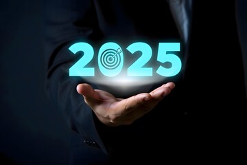 A person holding a glowing twenty twenty five with a target in their hand in a dark background