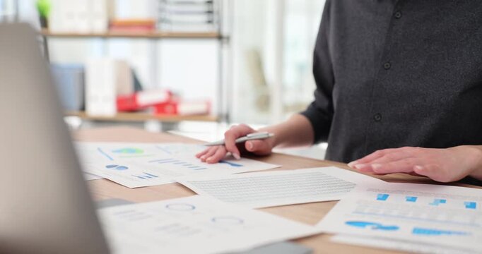 Businesswoman works with corporate charts and diagrams performing data in office. Female entrepreneur analyzes profit of company at workplace