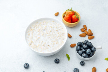 Oatmeal porridge with blueberries, strawberries, almonds and milk