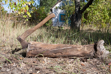 a massive axe inserted into a log frame against a rural backdrop