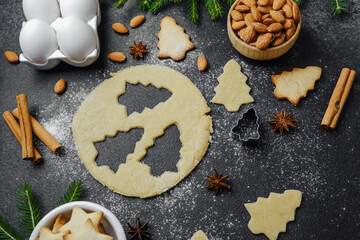 Holiday cookie dough and almond baking setup with festive decor and spices for christmas culinary...