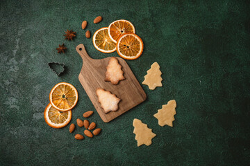 Christmas tree cookies with raw dough and wooden board for holiday food styling and festive...