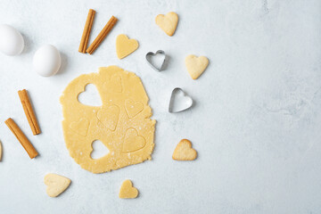 Heart shaped cookie dough cutting with cinnamon and eggs for baking, valentines or romantic concept