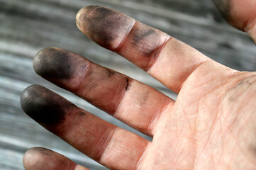a hand with automotive oil and grease, car maintenance concept, mechanic workshop, hand with dirt after car services, oil grease dirt on fingers of a hand, selective focus
