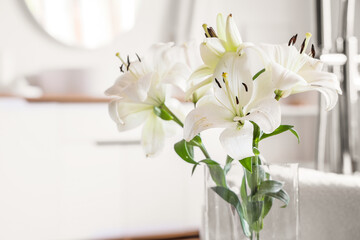 Vase with beautiful lily flowers in bathroom, closeup © Pixel-Shot