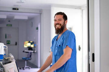 Fototapeta premium Smiling bearded healthcare professional working in hospital environment