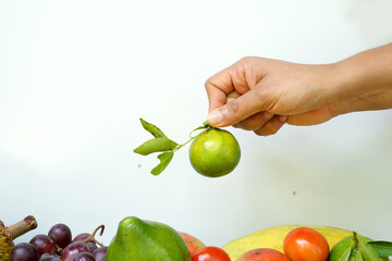 Woman hands holding fresh green lime fruit.