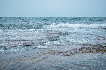Water landscape in the rain. Rocky ocean floor