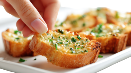 Hand picking a delicious garlic bread appetizer from a white plate