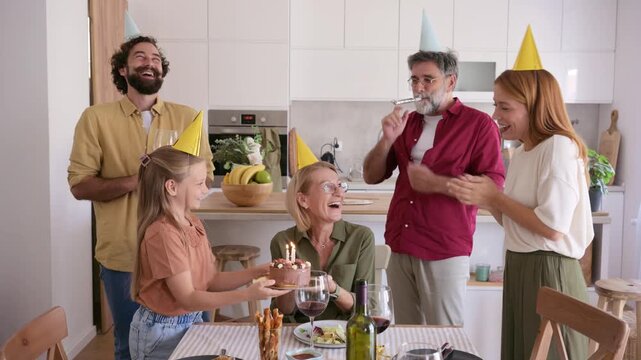 Multi generational family celebrating grandmother's birthday party at home