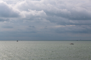 tranquil seascape with fishing boats and clouds