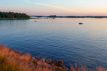 Fototapeta premium Calm lake with islands and pastel sky at sunset