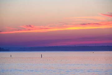 Calm sea at sunset with navigation buoys and distant coastline