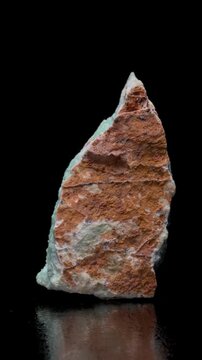 Chrysoprase (green form of chalcedony - SiO2) rotating slowly against a black background. Vertical.