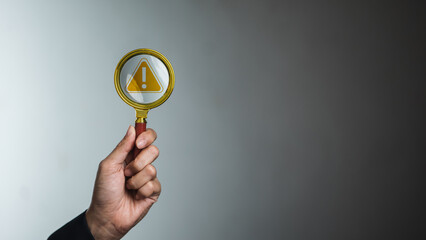 Risk alert under magnifying glass on dark background