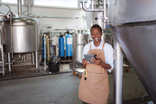 Brewmaster working in brewery inspecting beer production