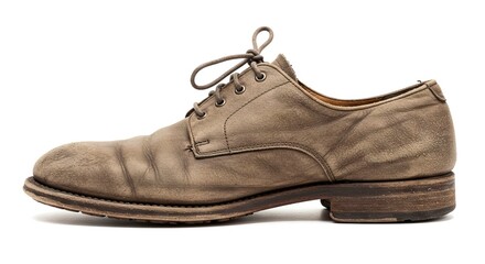 An old weathered leather dress shoe sits on a white background its laces tied in a loose knot