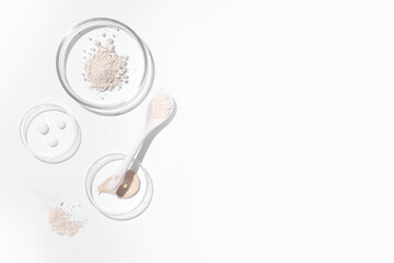Petri dish with powder and laboratory equipment on white background