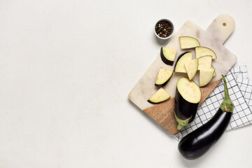 Composition with cut fresh eggplants, cutting board and napkin on white background
