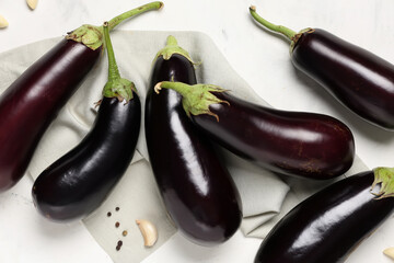 Composition with fresh eggplants, napkin and spices on white background, closeup
