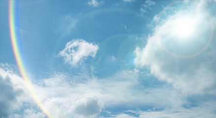 夏の晴天、青空に流れる積乱雲ふわふわの入道雲と輝く太陽のレンズフレア 夏・夏休み・行楽・バカンス・アウトドア・キャンプ・天気・台風一過・紫外線・日焼け 秋・秋晴れ