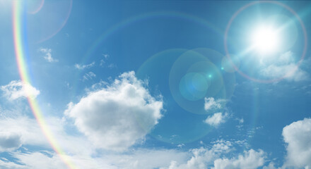 夏の晴天、青空に流れる積乱雲ふわふわの入道雲と輝く太陽のレンズフレア 夏・夏休み・行楽・バカンス・アウトドア・キャンプ・天気・台風一過・紫外線・日焼け 秋・秋晴れ