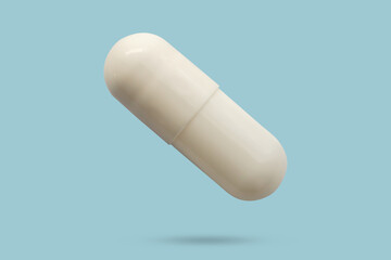 White medicine pill capsule float on blue background
