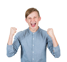 Overjoyed male teenager screaming happiness, raising up his fists, feels victorious as celebrates...