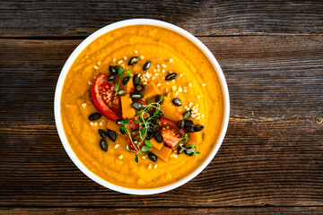 Pumpkin cream soup on wooden table. Top view