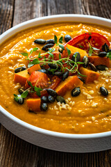 Pumpkin cream soup on wooden table	
