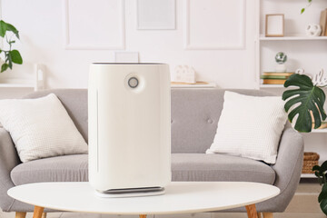 Modern air purifier on coffee table in stylish living room, closeup