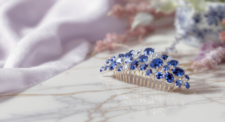 Elegant sapphire jewelry hair comb beautiful decor element. This romantic blue crystal accessory rests on marble table