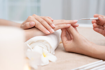 Fototapeta premium Woman receive care service by professional Beautician Manicure at spa centre. Nail beauty salon use nail file for Glazing treatment. manicurist make nail customer to beautiful. body care spa treatment